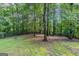 Backyard showcasing mature trees and a mossy lawn for a natural setting at 5341 Terrytown Ln, Lithonia, GA 30038