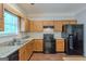 Traditional kitchen featuring wood cabinets, granite countertops, and black appliances with lots of natural light at 5341 Terrytown Ln, Lithonia, GA 30038