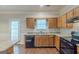 Well-lit kitchen with wood cabinets, granite countertops, and modern black appliances at 5341 Terrytown Ln, Lithonia, GA 30038