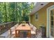 Spacious outdoor dining area on a wooden deck surrounded by lush greenery and natural light at 5341 Terrytown Ln, Lithonia, GA 30038