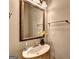 Bathroom featuring a single sink with brass fixtures, a mirror, and a window at 711 Topsail Ln, Alpharetta, GA 30005