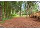 The backyard features a staircase leading to a wooden deck amidst lush trees at 2487 Highland Se Dr, Conyers, GA 30013