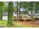 Backyard view of the house featuring a wooden deck and staircase amidst lush greenery at 2487 Highland Se Dr, Conyers, GA 30013