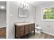 This bathroom has a wood vanity with a granite countertop and a window at 2487 Highland Se Dr, Conyers, GA 30013