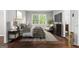 A staged bedroom features a large window, accent chair, and side tables at 2487 Highland Se Dr, Conyers, GA 30013