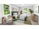 Staged bedroom with two large windows, modern décor, light walls and new gray floors at 2487 Highland Se Dr, Conyers, GA 30013