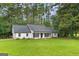 Charming one-story white home with mature trees and a green lawn at 2487 Highland Se Dr, Conyers, GA 30013