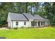 Bright one-story home with white siding, black shutters, green lawn and an attached garage on a sunny day at 2487 Highland Se Dr, Conyers, GA 30013