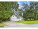 Side view of white home with a one-car garage, green lawn and a long driveway at 2487 Highland Se Dr, Conyers, GA 30013