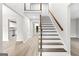 Bright foyer featuring hardwood floors, a staircase with wood railings, and white wainscoting at 2487 Highland Se Dr, Conyers, GA 30013