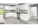 A bright kitchen features stainless dishwasher, gray wood-look flooring and granite counter tops at 2487 Highland Se Dr, Conyers, GA 30013