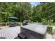 Large backyard deck featuring a table, umbrella, grill, hot tub and steps to a pool at 435 Hampton Grn, Peachtree City, GA 30269