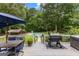 Spacious backyard deck with grill, table, umbrella, and steps leading to the inviting pool area at 435 Hampton Grn, Peachtree City, GA 30269