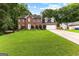 Charming two-story brick home featuring a well-manicured lawn and attached two-car garage at 435 Hampton Grn, Peachtree City, GA 30269