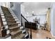 Entryway showcasing hardwood floors, carpeted stairs, and a view of the living room with a fireplace at 435 Hampton Grn, Peachtree City, GA 30269