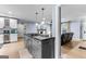 Open-concept kitchen featuring a large island with cooktop and seating, flowing into the living area with a fireplace at 435 Hampton Grn, Peachtree City, GA 30269
