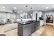 Modern kitchen featuring an island with cooktop and bar seating, open to the living area with ample natural light at 435 Hampton Grn, Peachtree City, GA 30269
