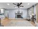 Cozy living room features a decorative fireplace, ceiling fan, and hardwood floors at 435 Hampton Grn, Peachtree City, GA 30269