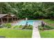 A refreshing swimming pool nestled in a lush backyard with a covered patio area at 435 Hampton Grn, Peachtree City, GA 30269