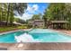 A large backyard swimming pool with a covered patio area and house visible in the background at 435 Hampton Grn, Peachtree City, GA 30269