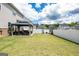 Expansive backyard with green lawn, white fence, and covered patio area at 13568 Scenic Pkwy, Covington, GA 30014