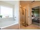 Bright bathroom featuring a soaking tub, separate shower, and neutral finishes at 13568 Scenic Pkwy, Covington, GA 30014