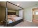 Spacious bedroom featuring a four-poster bed, carpet floors, and a walk-in closet at 13568 Scenic Pkwy, Covington, GA 30014