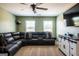 Inviting bonus room with a large sectional sofa, a modern media console, and ample natural light at 13568 Scenic Pkwy, Covington, GA 30014