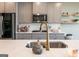 Kitchen featuring a stainless steel sink with modern faucet, gas stovetop, and ample storage at 13568 Scenic Pkwy, Covington, GA 30014