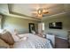 Spacious bedroom with a large mirror, TV, ceiling fan, and relaxing seating area at 13568 Scenic Pkwy, Covington, GA 30014