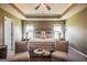 Comfortable bedroom features a tray ceiling, ceiling fan, and two chairs at 13568 Scenic Pkwy, Covington, GA 30014