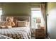 Inviting bedroom featuring a plush teddy bear, comfortable bedding, and natural light at 13568 Scenic Pkwy, Covington, GA 30014