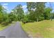 Long driveway leading to a private estate with mature trees and manicured landscaping at 1572 Azalea Dr, Lawrenceville, GA 30043