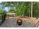 Backyard fire pit with wood shelter among the trees creates a cozy and natural ambiance at 1572 Azalea Dr, Lawrenceville, GA 30043