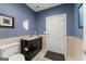 Bathroom with black vanity and granite countertop, tile detail and an oval mirror at 1572 Azalea Dr, Lawrenceville, GA 30043