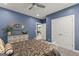 Bedroom boasts blue walls, ceiling fan, and a decorative dresser with gold mirror at 1572 Azalea Dr, Lawrenceville, GA 30043