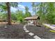 Backyard with outdoor pavilion featuring a garden swing, cafe table and chairs, and patio seating surrounded by mature trees at 1572 Azalea Dr, Lawrenceville, GA 30043