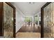Inviting foyer featuring hardwood floors, elegant doors, and a view of the dining and living areas at 1572 Azalea Dr, Lawrenceville, GA 30043