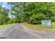 Driveway sign leading to estate with long paved drive winding through mature trees and lush landscaping at 1572 Azalea Dr, Lawrenceville, GA 30043