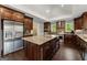 Spacious kitchen with stainless steel appliances, dark wood cabinets, granite countertops and a large kitchen island with seating at 1572 Azalea Dr, Lawrenceville, GA 30043