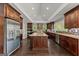 Spacious kitchen with dark wood cabinets, granite countertops, stainless steel appliances, and a large kitchen island at 1572 Azalea Dr, Lawrenceville, GA 30043