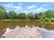 Scenic view of a private lake with a wooden dock and lush green trees reflecting in the water at 1572 Azalea Dr, Lawrenceville, GA 30043