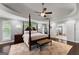 Spacious main bedroom with tray ceiling, ceiling fan, hardwood floors, and an ensuite bathroom at 1572 Azalea Dr, Lawrenceville, GA 30043