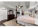 Spacious main bedroom featuring hardwood floors, ceiling fan, tray ceiling, and dresser with mirror at 1572 Azalea Dr, Lawrenceville, GA 30043