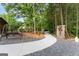 Inviting walkway through the backyard landscaping with lush greenery and charming details at 1572 Azalea Dr, Lawrenceville, GA 30043
