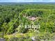 Aerial view showcasing approximate property lines of an 8.34-acre lot with a home and lush surrounding trees at 1572 Azalea Dr, Lawrenceville, GA 30043