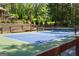 Well-maintained private blue and green tennis court surrounded by lush greenery, perfect for recreational play at 1572 Azalea Dr, Lawrenceville, GA 30043