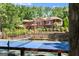 Well-maintained private blue and green tennis court with a net in front of a sprawling house and lush greenery at 1572 Azalea Dr, Lawrenceville, GA 30043