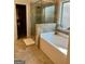 Bathroom featuring soaking tub, glass enclosed shower, and tile flooring at 2208 Ginger Lake Ne Dr, Conyers, GA 30013