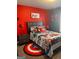 Fun bedroom with red accent wall, bed with comic themed bedding, and matching decor at 2208 Ginger Lake Ne Dr, Conyers, GA 30013